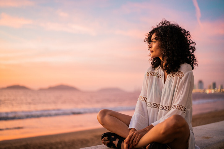 Peaceful woman overlooking nature, symbolizing stress relief, nervous system regulation, and emotional balance through acupuncture